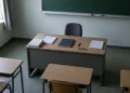 Порожній учительський стіл із класним журналом у шкільному кабінеті